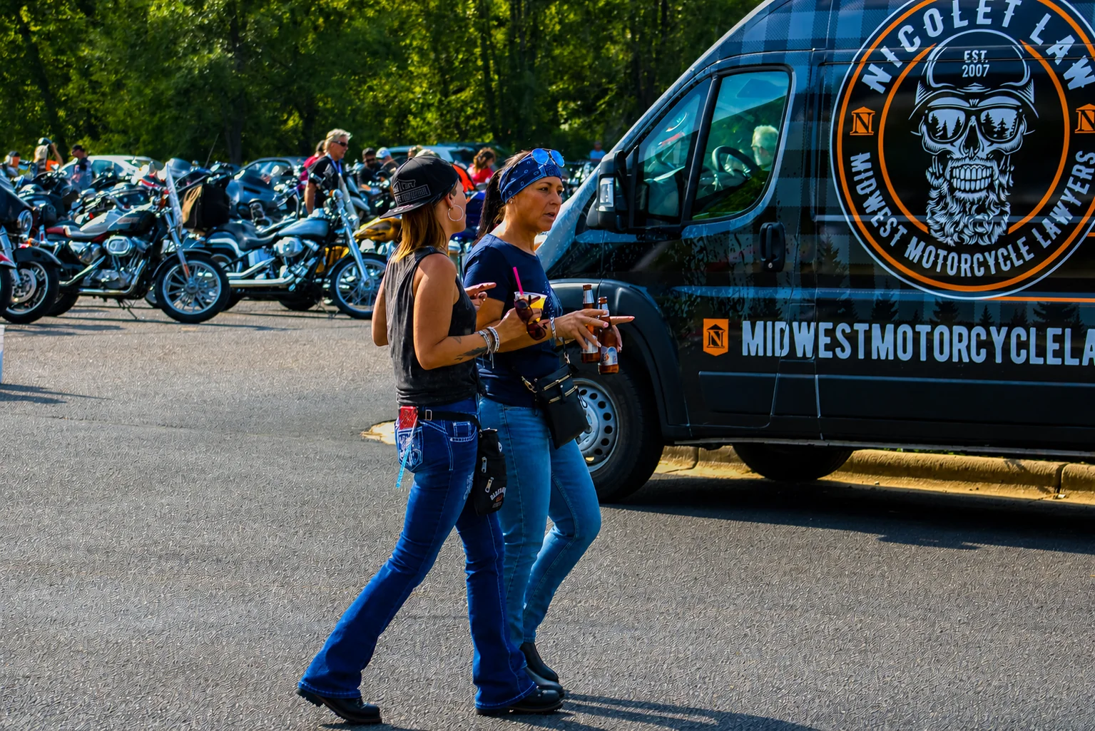 Two women walking past the Midwest Motorcycle Law display