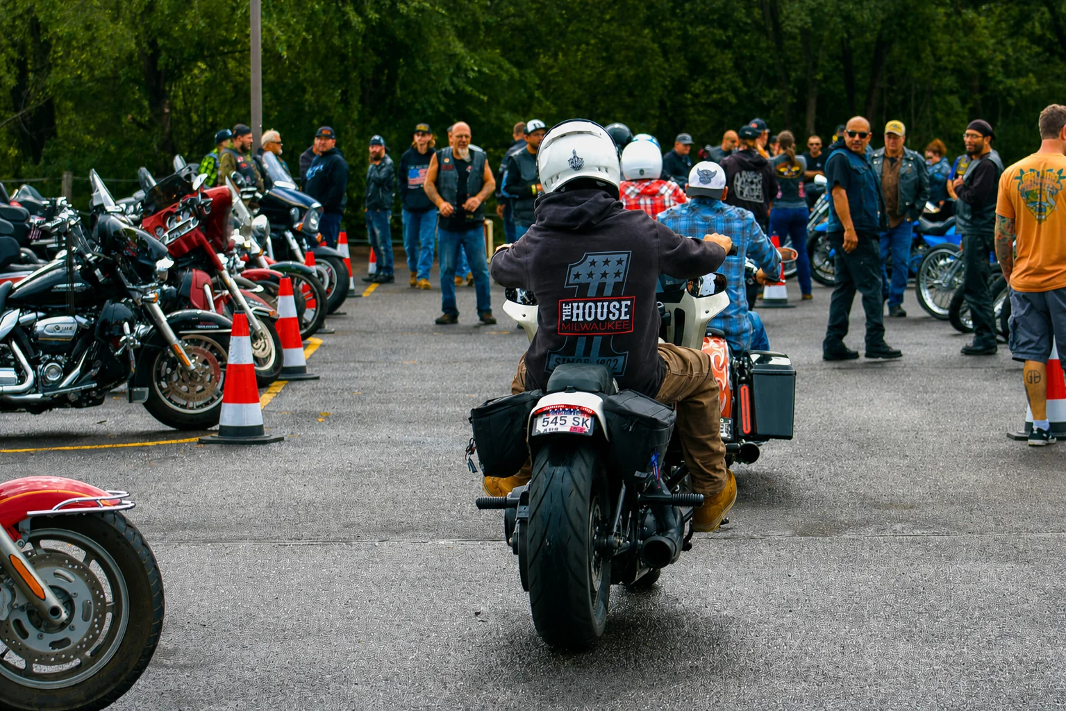 A motorcyclist entering between rows of motorcycles and spectators